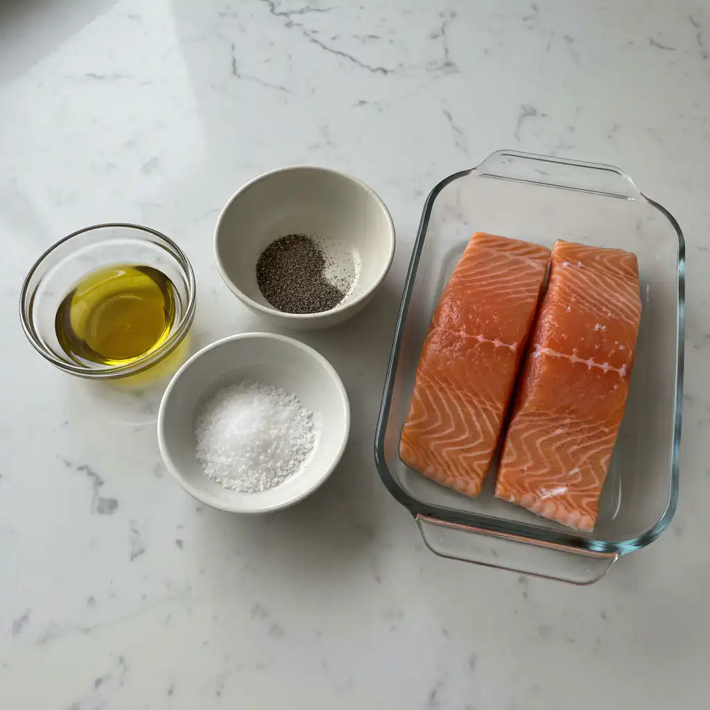 pan-seared-salmon-ingredients A close-up of fresh salmon fillets, lemons, and herbs beautifully arranged, ready for a delicious pan seared salmon meal.